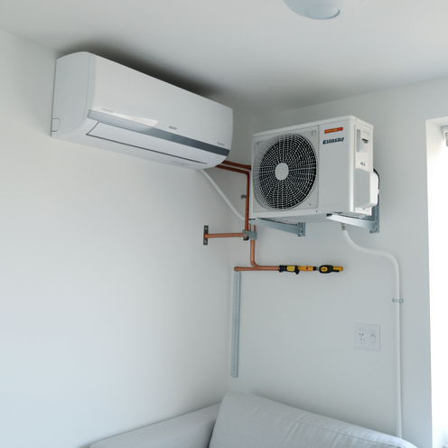 Climatiseur split mural et unité extérieure présentés avec les éléments nécessaires à leur installation dans un appartement moderne.